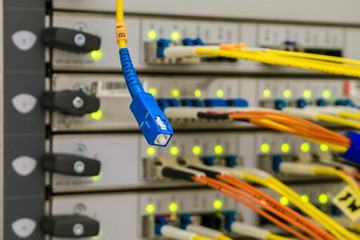 Fiber optic Patch-Cord is on the background of optical links of the central server router