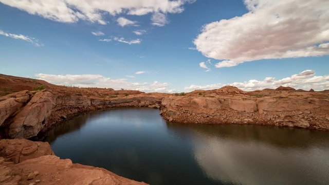 Time lapse of clouds moving over water at Lake Powell viewing the red rock landscape in Utah.