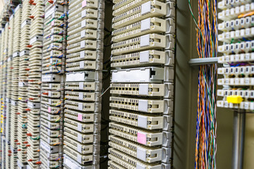 telephone switchboard panel is in the server room. Many multi-colored wires intertwine intertwine on the switching board