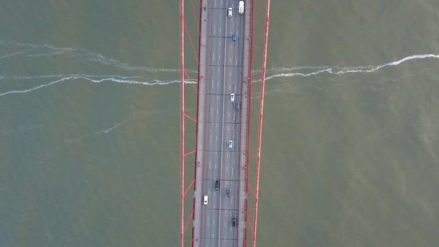 Overhead aerial, cars drive on Golden Gate Bridge