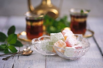 traditional oriental dessert Turkish Delight on an old table  with mint tea