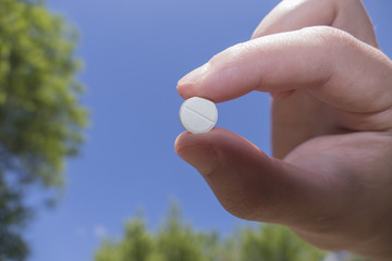 Capsule in hand against sky background