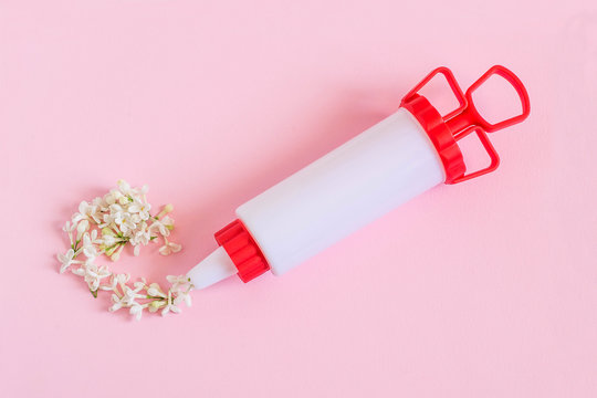 Creative idea: confectionery syringe and white lilac flowers instead of cream