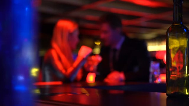 Man first meeting with lady in nightclub, talking privately, romantic atmosphere
