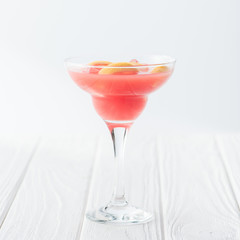 close up view of tasty summer margarita cocktail on white wooden tabletop on grey backdrop