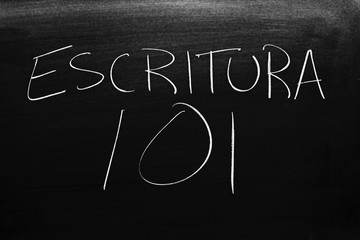 The words Escritura 101 on a blackboard in chalk.  Translation: Writing 101