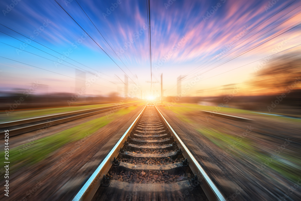 Wall mural railway station with motion blur effect at sunset. blurred railroad. industrial conceptual landscape