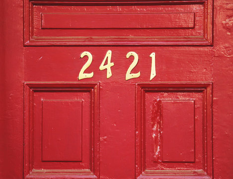 Red Wooden Door With Gold Numbers