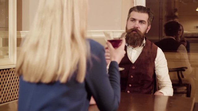 Couple in love. Handsome man flirting with cute woman in restaurant. Bearded man flirting with young sexy blonde