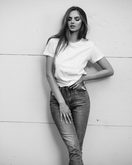 Beautiful girl in jeans and a T-shirt on the street. Black and white photo