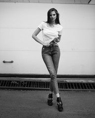 Beautiful girl in jeans and a T-shirt on the street. Black and white photo