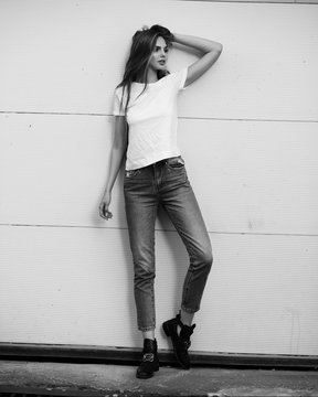 Beautiful girl in jeans and a T-shirt on the street. Black and white photo