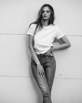 Beautiful girl in jeans and a T-shirt on the street. Black and white photo