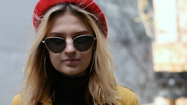 beautiful successful businesswoman outside looking at camera blinking eye smelling fowers and walking away confident stylish woman pretty lady casual clothes gesture emotional face cool sunglasses