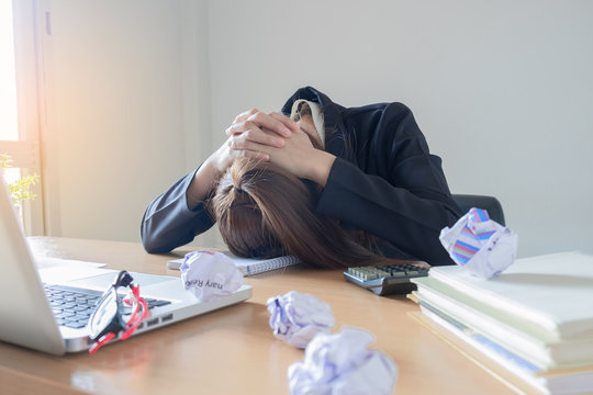 Businesswoman putting his head down on desk in office