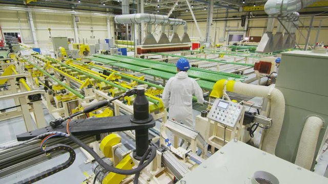 workers in white control special pipes production