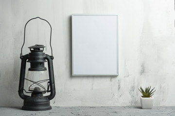 Empty white frame with a flower with a lamp on the wall background. The concept of design and font inscriptions and image placement