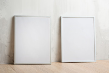 Two white frames on the wall background. The concept of design and font inscriptions and image placement