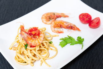 Linguine with shrimps and cherry tomatoes. The shrimps of the Mediterranean are precious crustaceans, the sauce is also accompanied by pepper and fresh parsley
