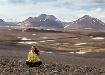 Fototapeta premium beautiful girl in yellow is engaged in yoga in the mountains of Iceland.