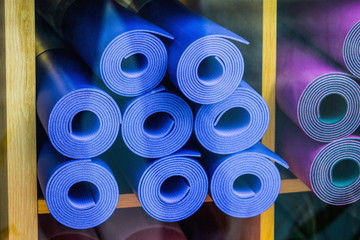 Close up image of yoga mats for sale through a shop window