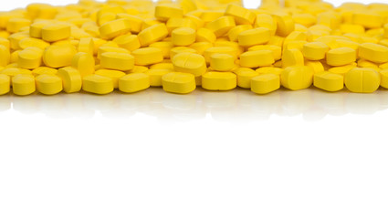 Pile of yellow ovoid-rectangular shape tablet pills isolated on white background with copy space. medicine for relief pain. Pharmaceutical industry. Global healthcare concept.