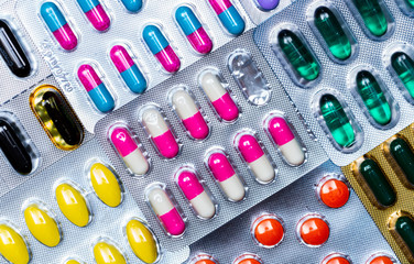 Colorful of tablets and capsules pill in blister packaging arranged with beautiful pattern with flare light. Pharmaceutical industry concept. Pharmacy drugstore. Antibiotic drug resistance. Defective.