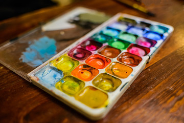 Set of watercolor paints and paintbrushes for painting closeup. Selective focus