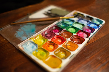 Set of watercolor paints and paintbrushes for painting closeup. Selective focus