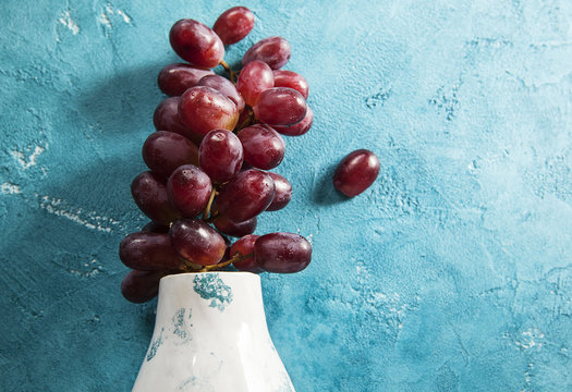 red grapes on a blue background, grapes bunches