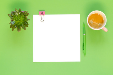 Empty paper with pink clip emoji, green pen, coffee cup and succulent