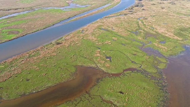 Aerial view of the Glaslyn Marshes close to the railway with the Snowdonia mountain range national park in background - Porthmadog, Wales - United Kingdom