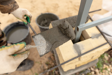 man builds a brick wall at a construction site