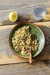 Pearl barley couscous green peas wooden table glass lemon water top view Healthy food concept