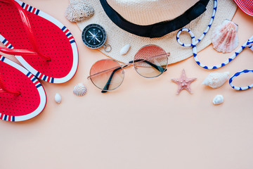 Summer fashion flatlay with gradient round sunglasses, straw hat, flats and red striped bikini top....