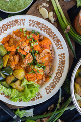 Soy meat with salsa ketchup hot sauce. Woman hands holds stewed, steamed, cooked veggies. Lunch, dinner new potatoes, eggplant, spinach leaves with garlic and herbs.  Raw vegan vegetarian healthy food