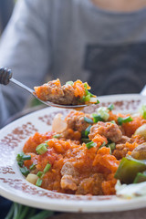 Soy meat with salsa ketchup hot sauce. Woman hands holds stewed, steamed, cooked veggies. Lunch, dinner new potatoes, eggplant, spinach leaves with garlic and herbs.  Raw vegan vegetarian healthy food