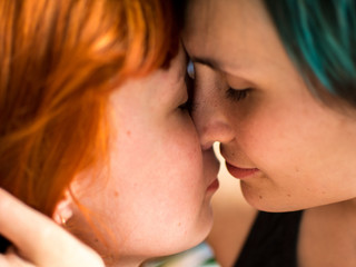 Portrait of two pretty girlfriends kissing