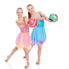 Girls gymnasts perform exercises with the ball.