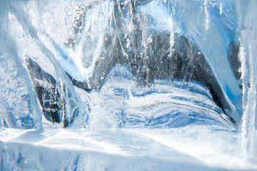 Obraz na płótnie Canvas Beautiful blue texture of transparent winter ice with rainbow colors
