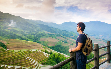Fototapeta na wymiar Man enjoying stunning Asian rice terrace scenery