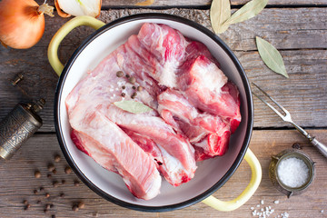 Raw pork on bone for soup (broth) with spices, top view, selective focus