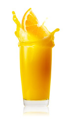 Orange slice flying in tall glass of orange juice