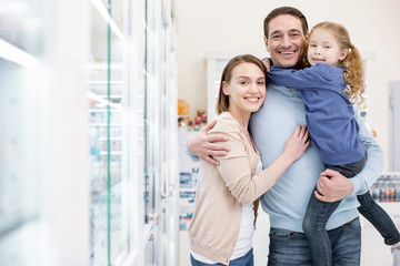 Vitamins for family. Energetic exuberant family embracing and looking at camera