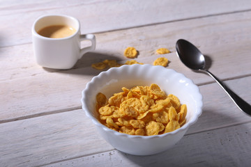 Corn Flakes cereal in a bowl and cap with espresso coffee. Morning breakfast.