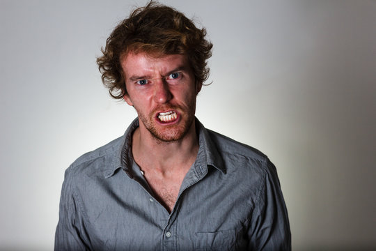 Angry young man with clenched teeth