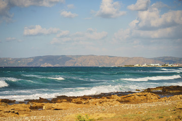 Beautiful seascape with blue sea waves on a rocky beach, Crete, Greece.