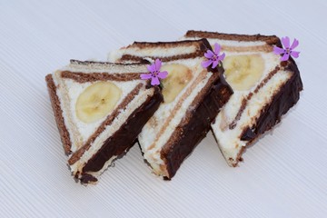Slices of unbaked dessert in triangle shape made of flat light and dark biscuits