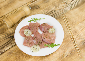 Raw chicken fillet sprinkled with spices on a wooden background. Preparation for cooking.