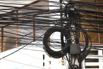 a bundle of electrical wires on a pole, electrical wires in a big city, coils of wire